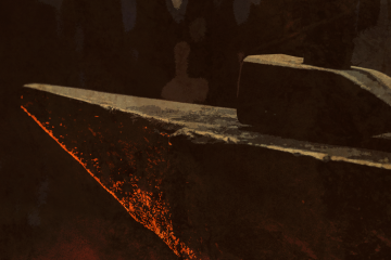 Un yunque con un martillo apoyado bocabajo en la parte superior. Un destello anaranjado, como el que podría producir un fuego cercano, hace brillar la parte inferior del yunque.